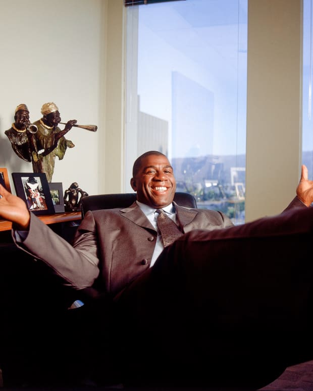 Former Laker Earvin (Magic) Johnson poses at his desk in his office in Beverly Hills, CA in July, 2001.