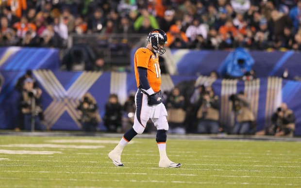 Peyton Manning in his new Broncos jersey flanked by Eli Manning