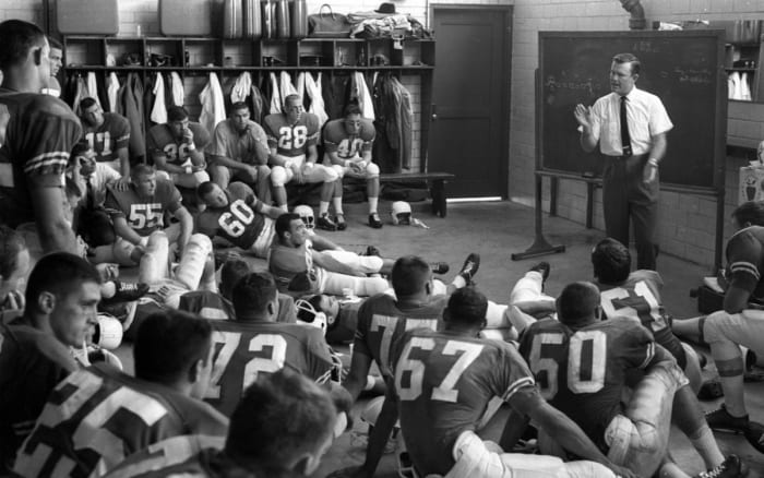 Texas coach Darrell Royal talking to Tommy Nobis (60) and rest of the team in locker room before game vs Oklahoma at Cotton Bowl Stadium.