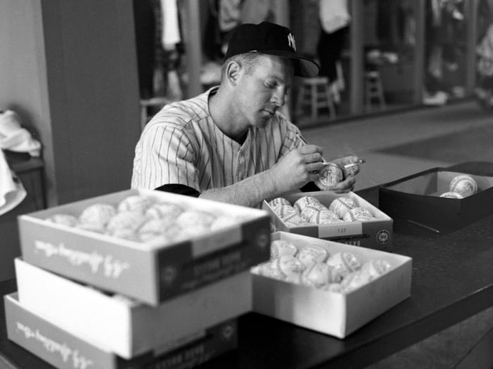 Whitey Ford signing baseballs