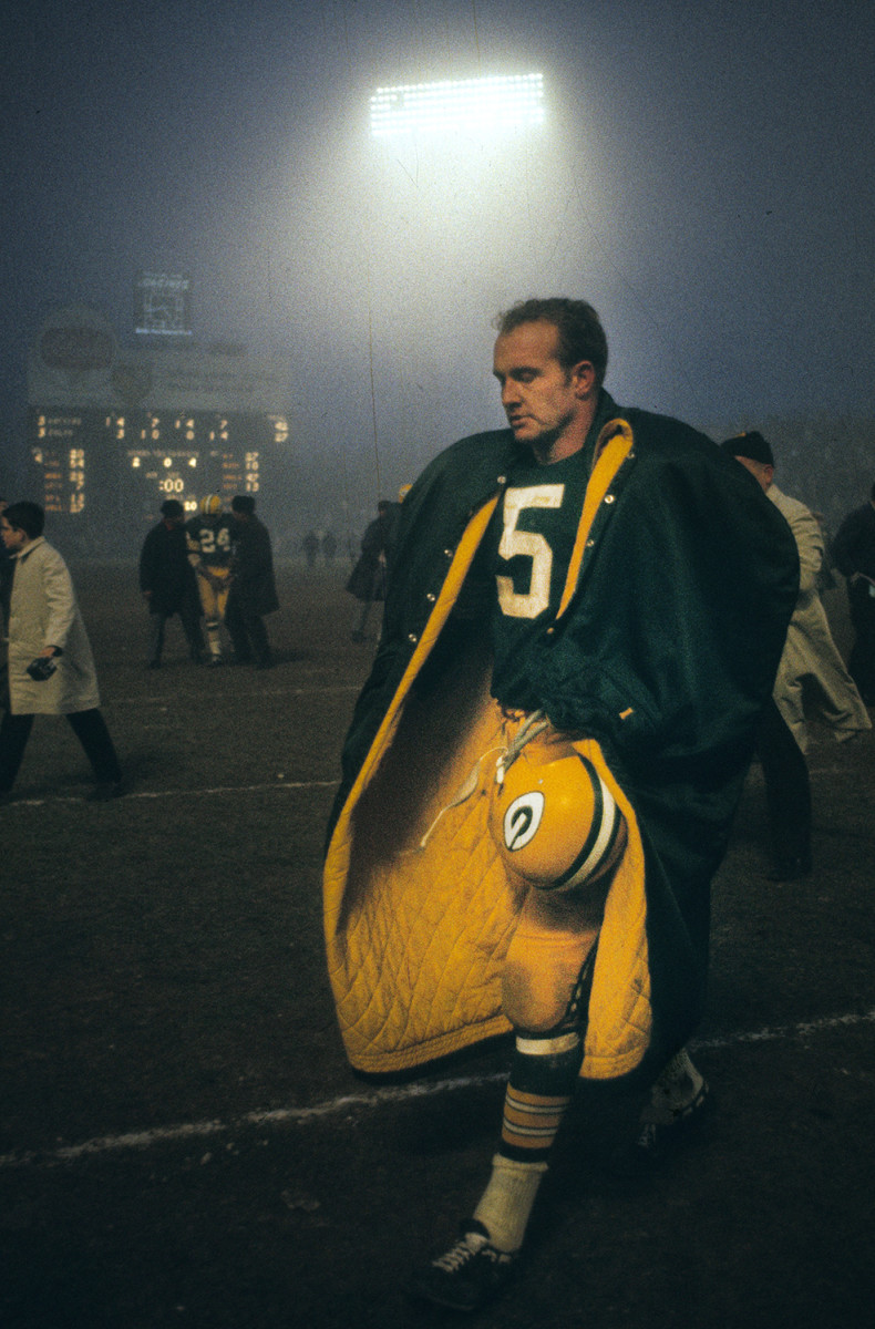 Paul Hornung, wearing team-issued coat, leaves the field after a Packers game at Lambeau Field