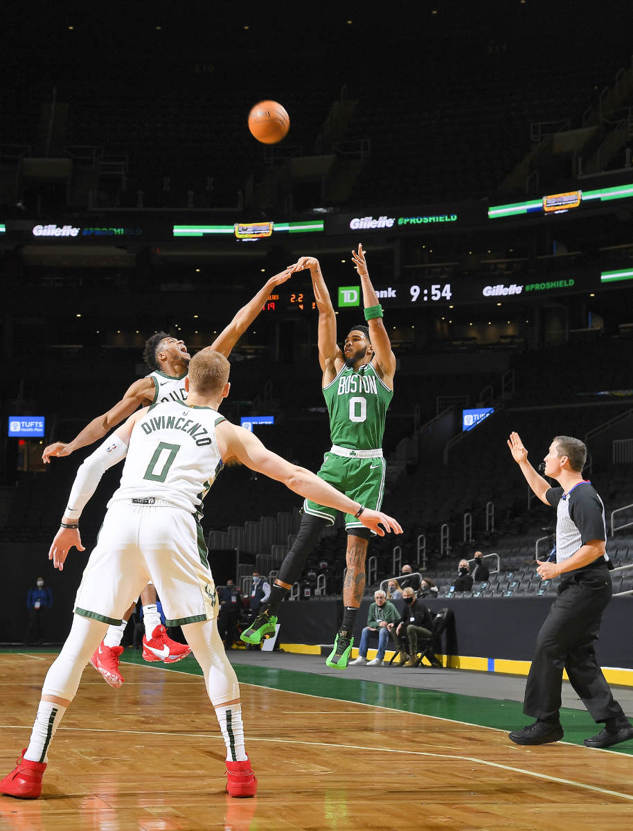 TRIPLE THREAT Tatum—who is averaging more than twice as many three-point attempts as he did two years ago when he relied on midrange Js—nailed a three to beat the Bucks in the season opener.